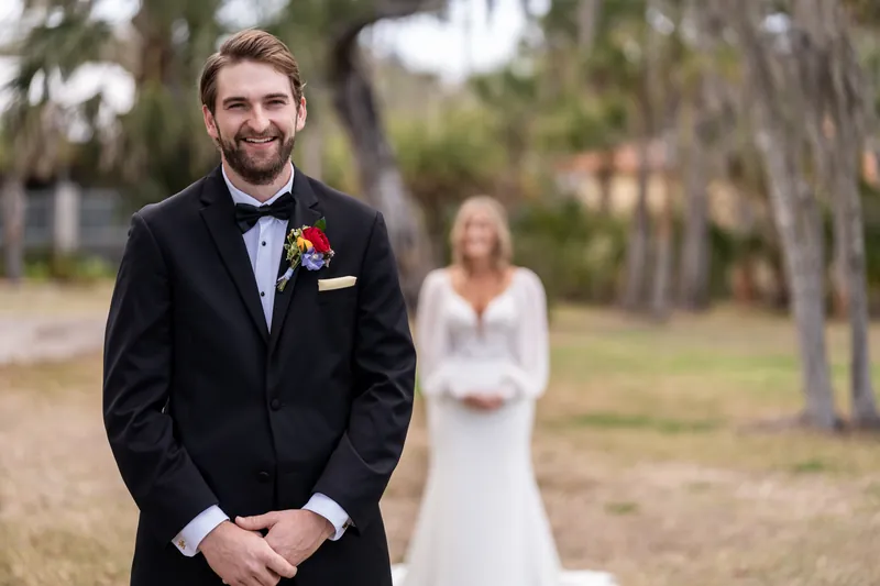 Groom smiling as bride approaches for first look at Fountain of Youth
