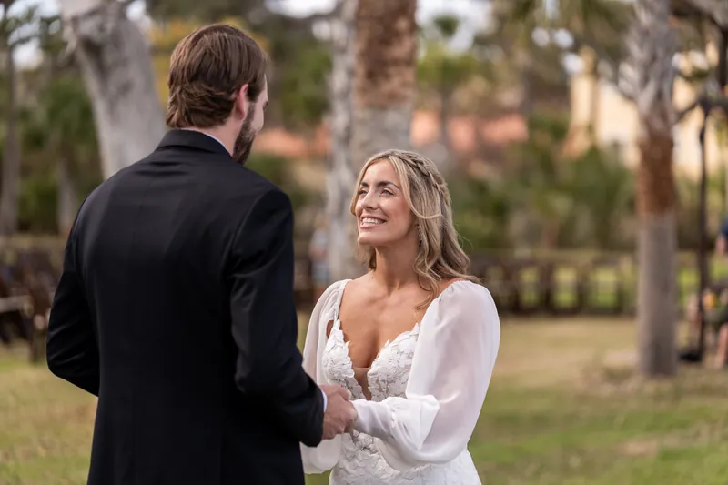 Bride smiling up at groom during first look under Spanish moss