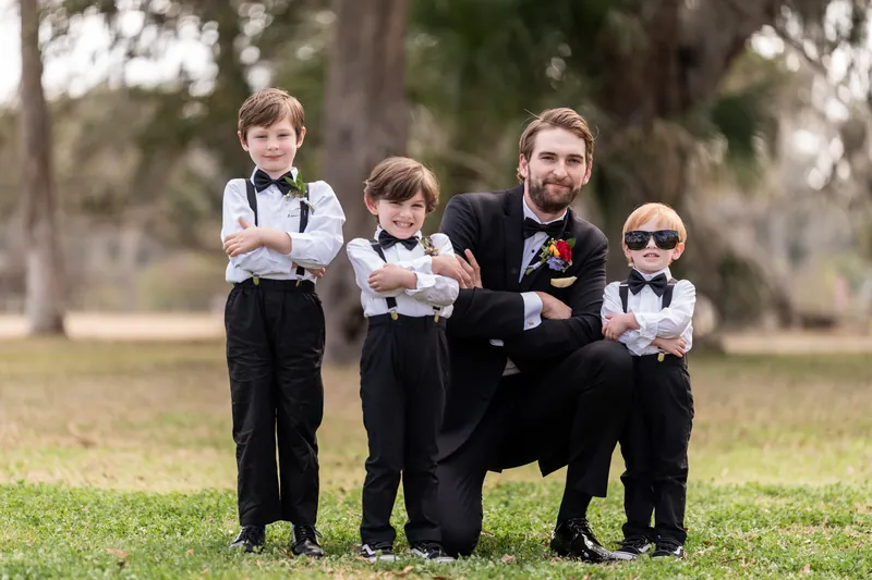 Groom with ring bearers in matching suspenders and bow ties
