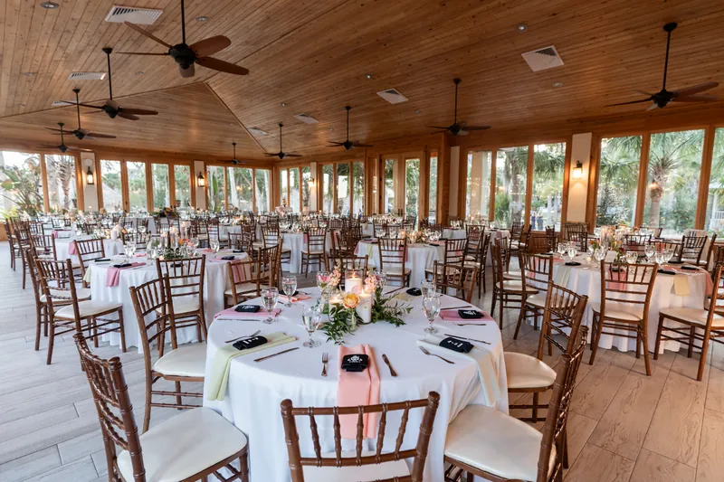 Reception pavilion wide shot with wood ceiling, ceiling fans, and full table setup