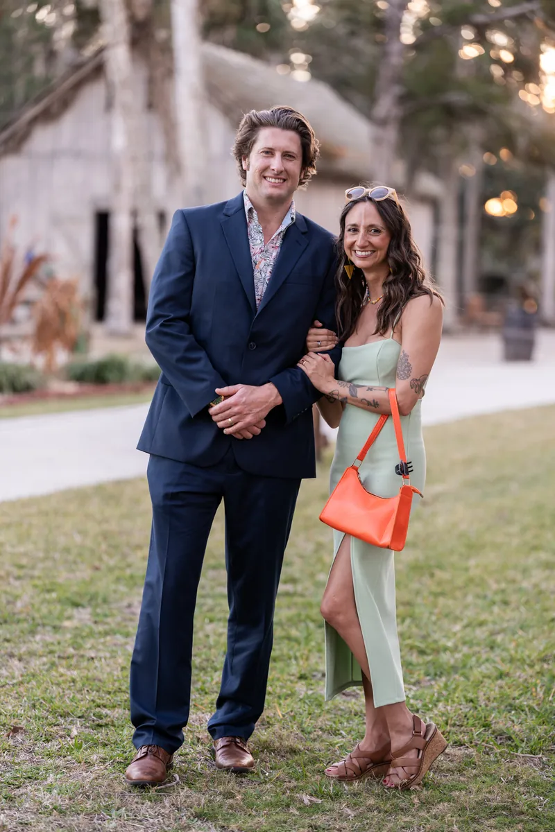 Guest couple portrait in navy suit and sage dress at golden hour