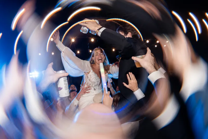 Bride laughing in center of dance floor with spin light-painting effect