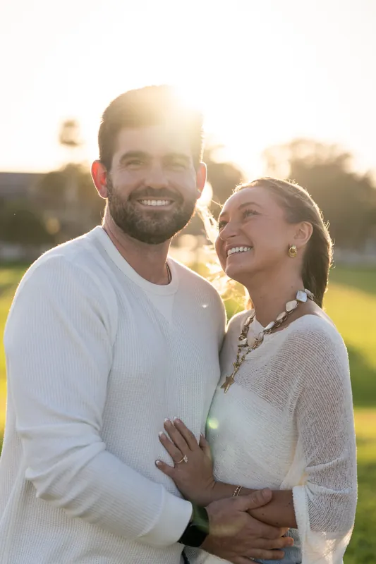 Matt and Mary smile together at golden hour near the fort's stone walls at Castillo de San Marcos.