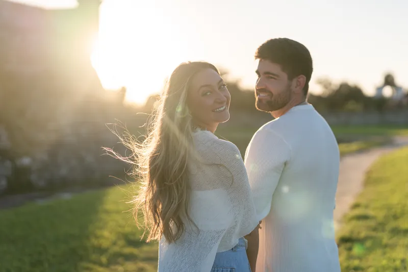 Standing together in evening light at Castillo de San Marcos, Matt and Mary gaze at each other as the sun sets behind them.