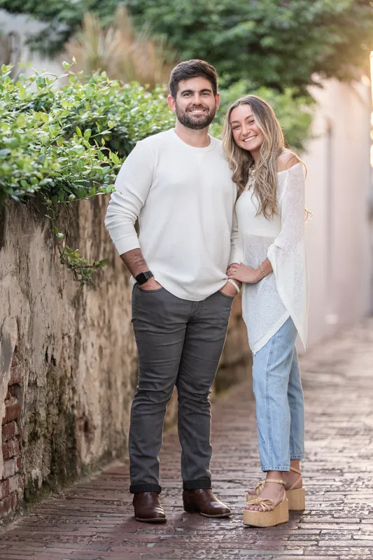 The couple walks along a cobblestone pathway lined with ivy-covered walls in downtown St. Augustine.