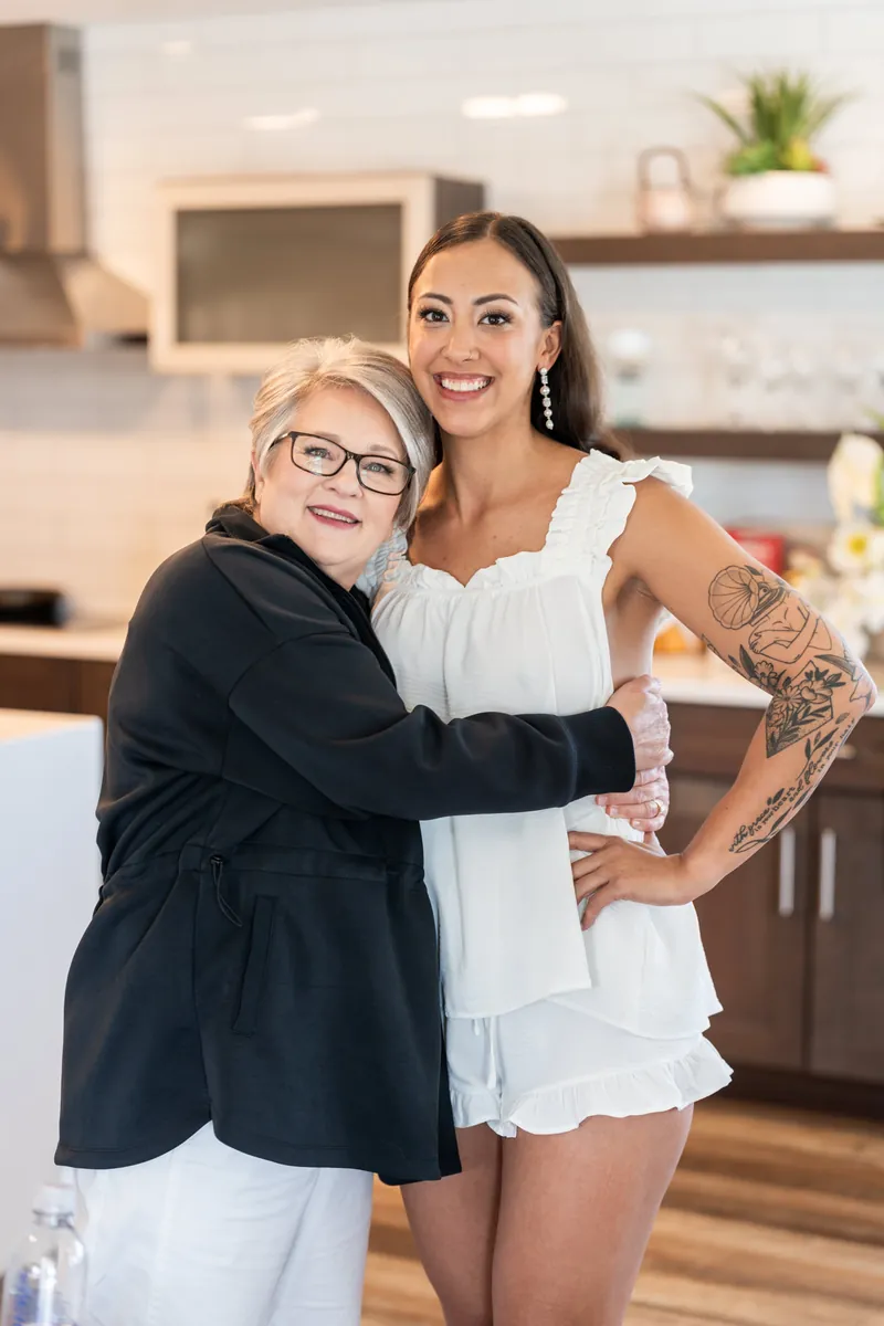 Bride holding tropical bouquet with orchids and anthuriums by a mirror