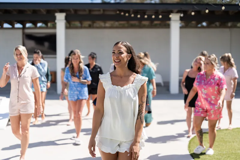 Michelle smiling and walking ahead of her bridal party at the venue