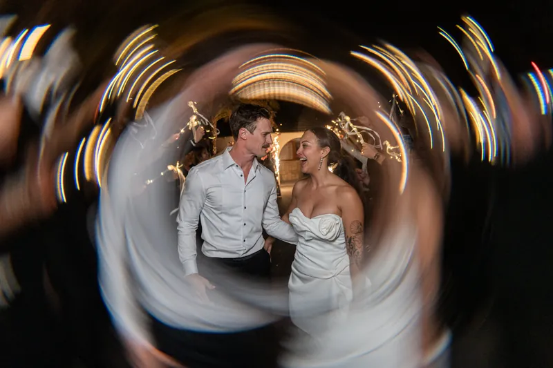 Sparkler exit with couple laughing and running through sparkler tunnel with light trails