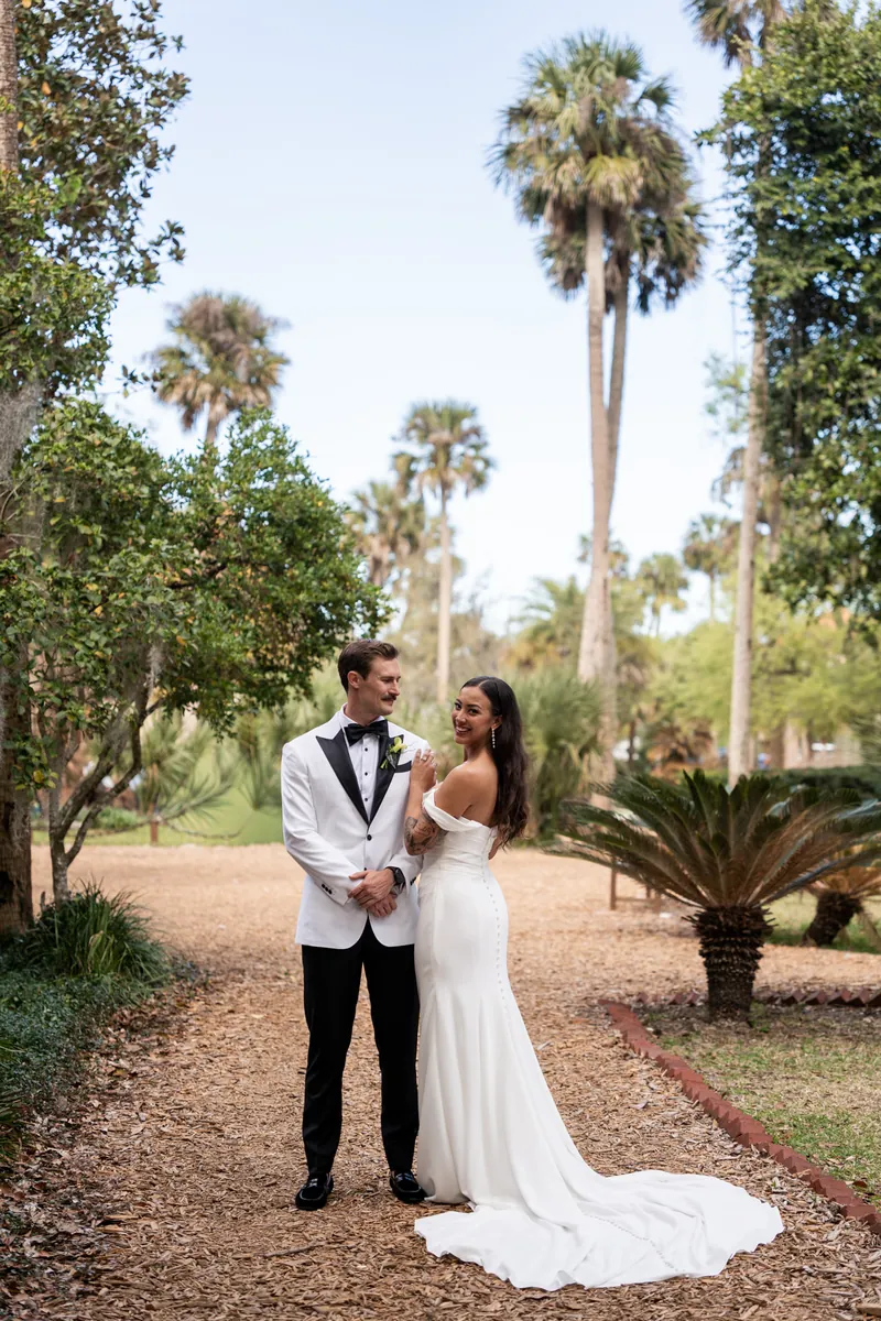 Couple portrait on garden pathway surrounded by palm trees at Fountain of Youth