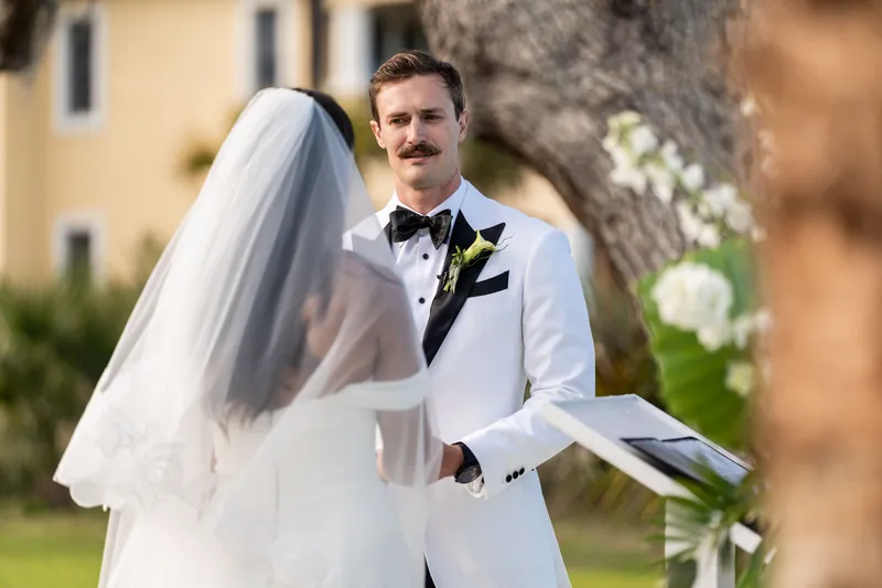 Groom reading vows to bride during outdoor ceremony at Fountain of Youth
