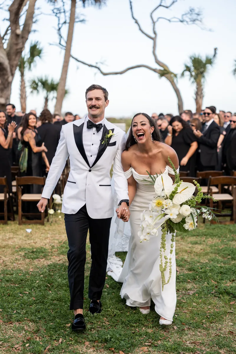 Bride approaching groom for first look with emotional expression and hands raised