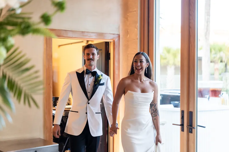 Couple entering the Magnolia Room hand in hand for the reception