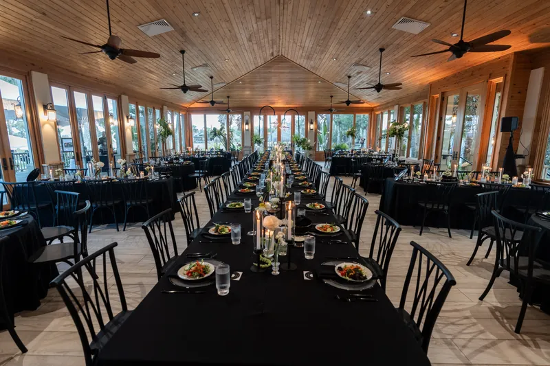 Wide shot of Magnolia Room reception setup with long and round tables and ceiling fans