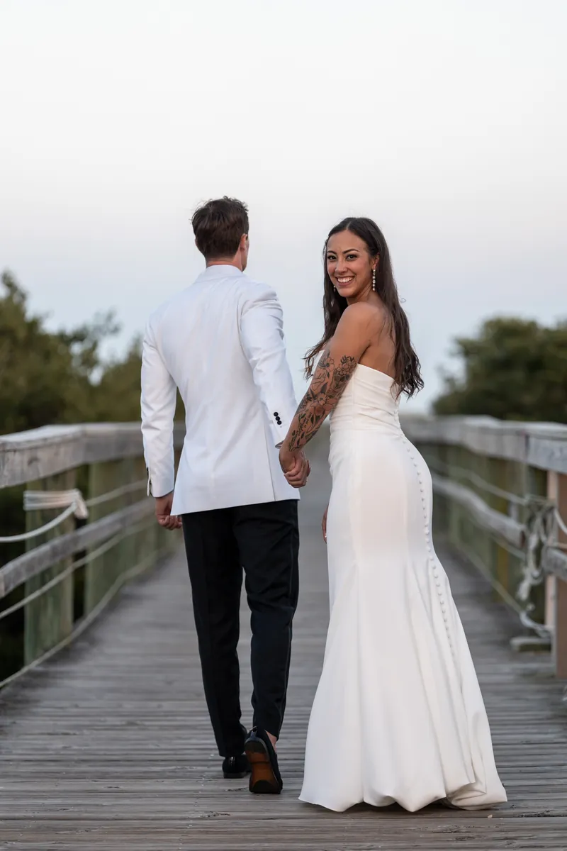Bride looking back over shoulder while walking on the Fountain of Youth boardwalk at dusk