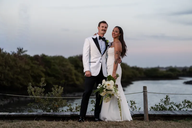Sunset portrait of couple with tropical bouquet by the waterfront at Fountain of Youth