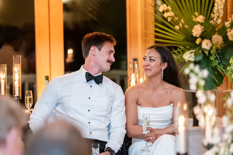 Couple looking at each other with candlelight during reception toasts