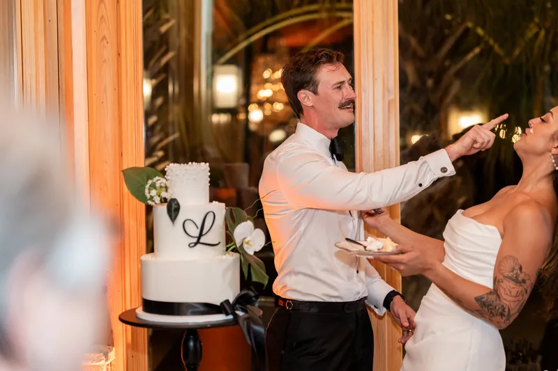 Bryant feeding Michelle cake while she laughs leaning back during cake cutting