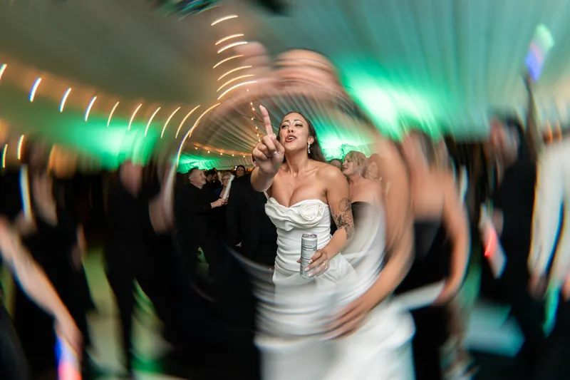 Michelle dancing on the dance floor with peace sign and light trail effect in green lights