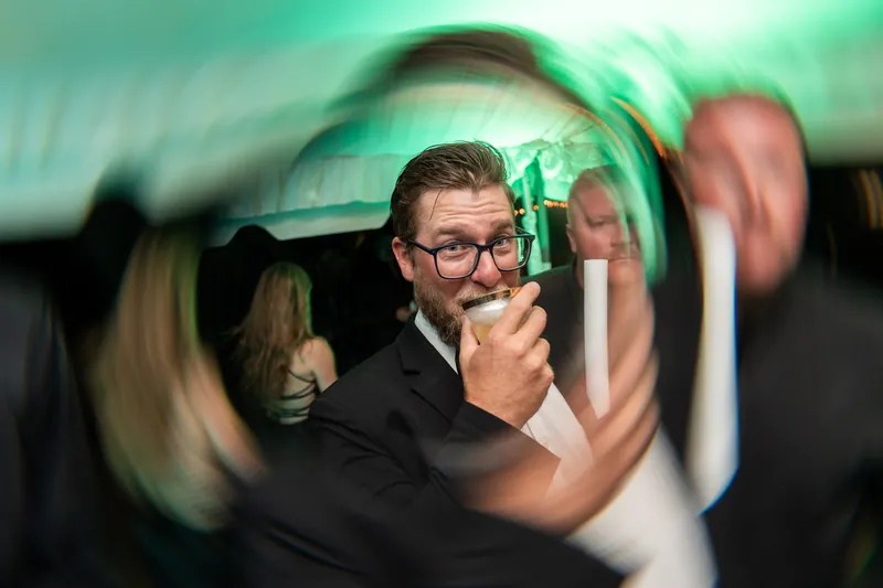 Guest sipping cocktail with light trail effect on the dance floor