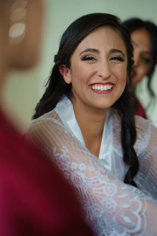 Monica beams with a wide smile, wrapped in a delicate white lace shawl at The Oldest House Museum.