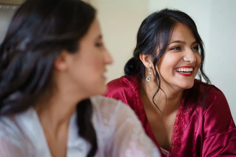 Monica grins while chatting with a companion in a white robe at The Oldest House Museum.