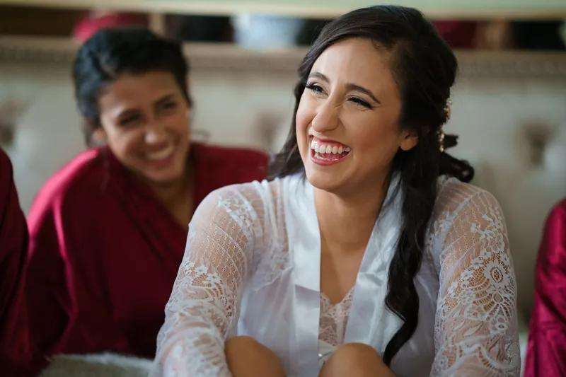 Monica smiles brightly surrounded by loved ones in coordinating robes before the ceremony.