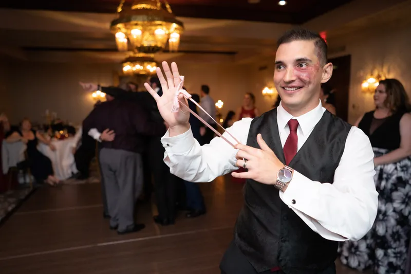 Michael gives a toast with microphone in hand, smiling at guests during the reception at Casa Monica Resort & Spa.