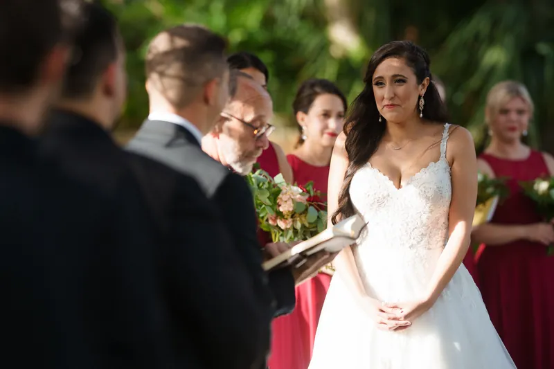 Monica listens intently as an officiant speaks during the outdoor ceremony at The Oldest House Museum.