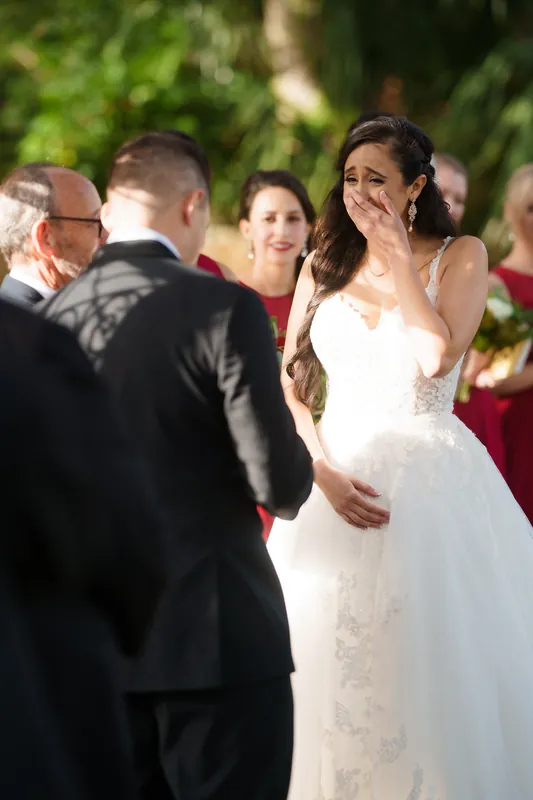 Michael reaches toward Monica's face as they stand together during their ceremony at The Oldest House Museum.