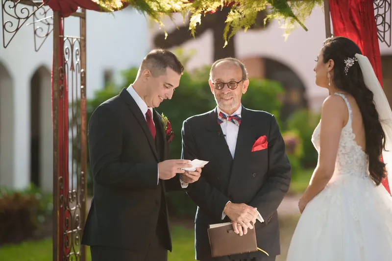 Michael holds the wedding rings while the officiant conducts their ceremony at The Oldest House Museum.