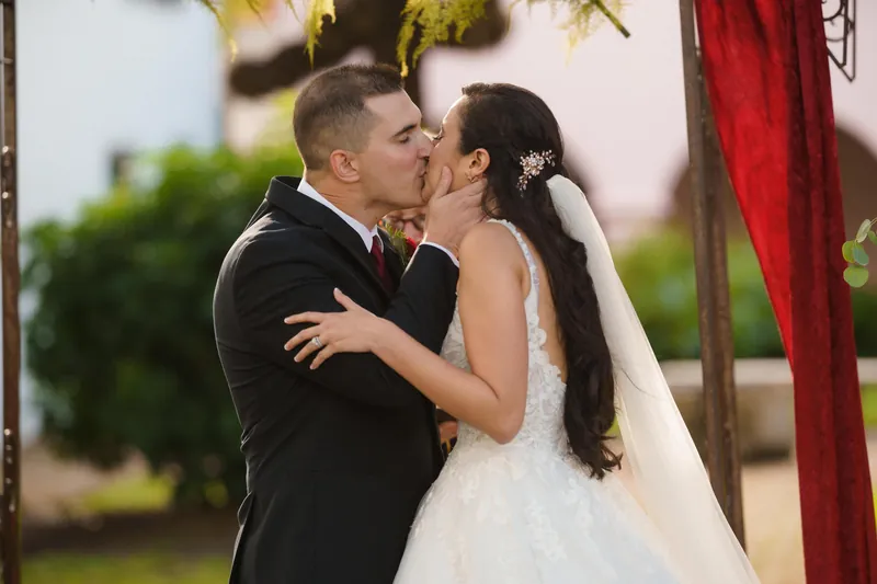 Monica and Michael kiss under the arch after being pronounced partners, their first kiss as a married couple.