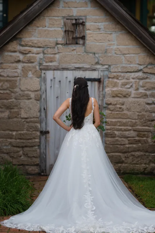Monica's lace wedding gown and train spread across the brick courtyard at The Oldest House Museum in St. Augustine.
