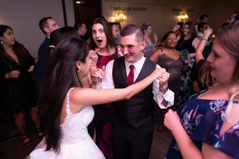 Michael dancing with Monica as guests clap and cheer around them on the dance floor.