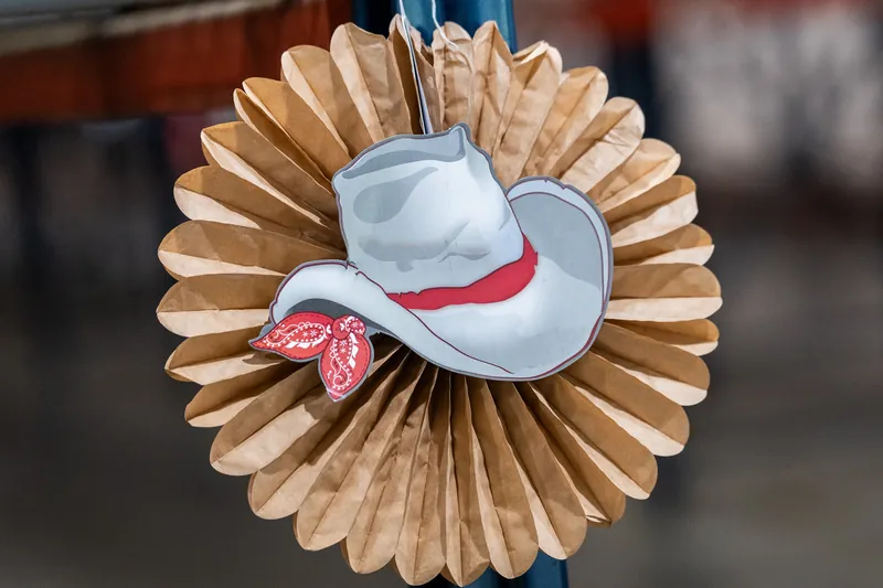 A white cowboy hat with a pink bandana sits atop a circular woven wood decoration at the Jacksonville Beach rodeo event.