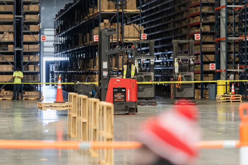Wet concrete floor of an indoor warehouse at Jacksonville Beach, St. Augustine, with orange traffic cones and safety equipment.