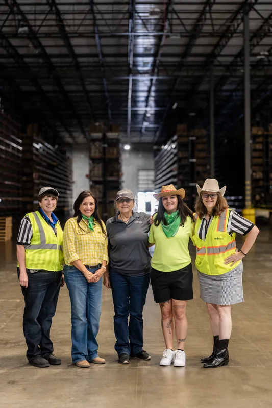 Five people in neon safety vests stand inside an industrial warehouse space at Jacksonville Beach, St. Augustine.