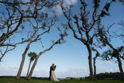 Patrick and Kallie embrace under Spanish moss-draped oak trees at their backyard elopement