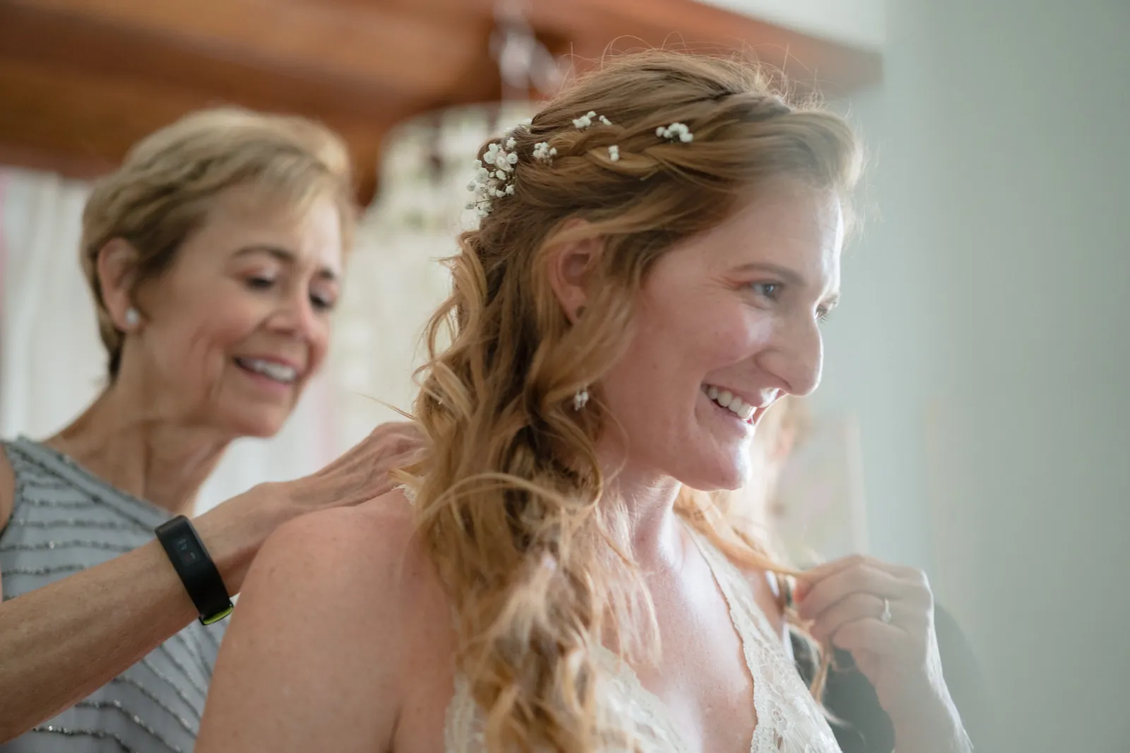 Mother of the bride helping adjust the bride's dress