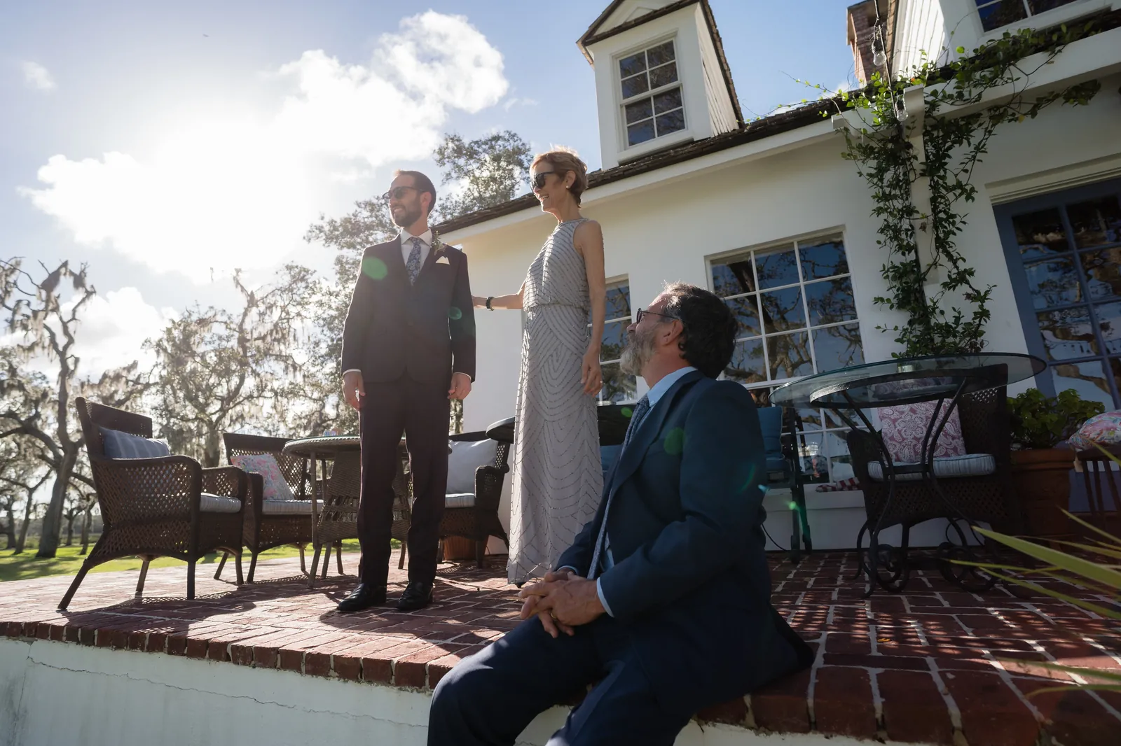 Wedding party and family on brick patio of white house