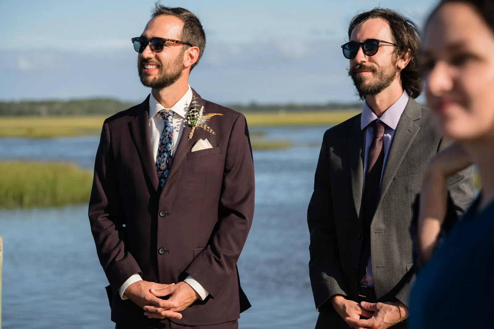 Groom and best man waiting by the marsh in coordinated suits