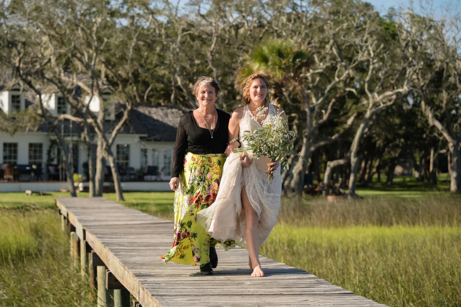 Mother walking bride down the dock toward ceremony