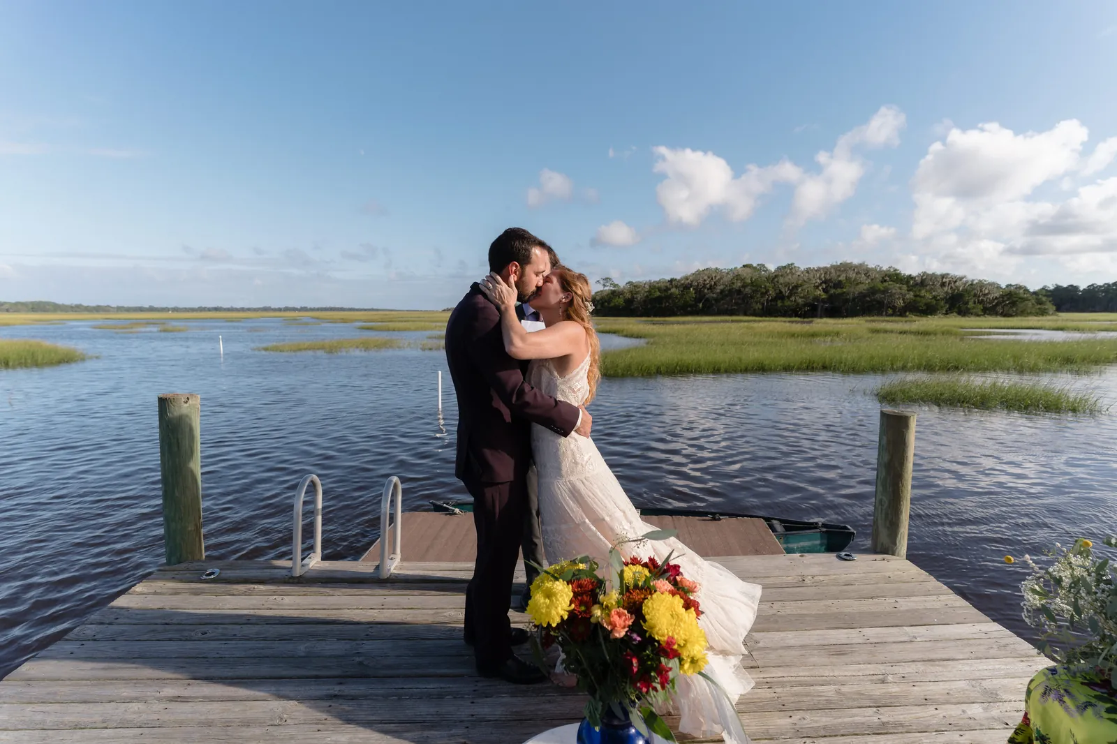 First kiss on the dock with marsh and sky backdrop