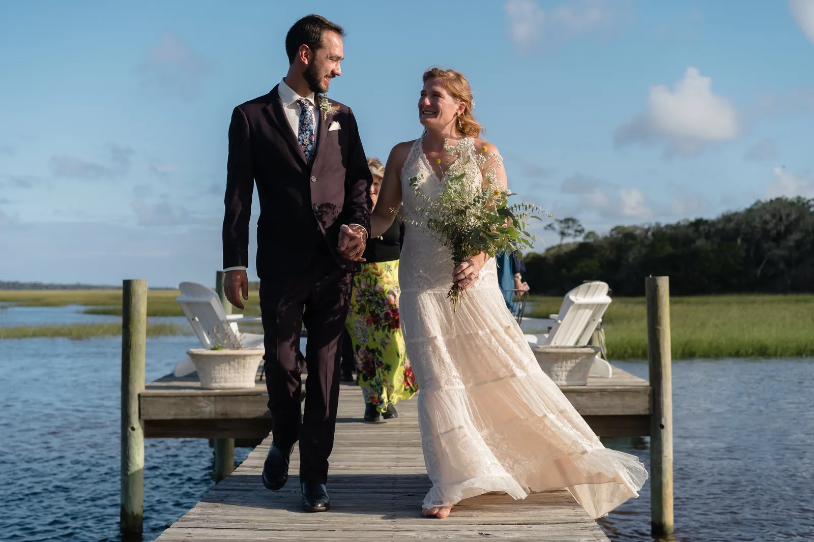 Newlyweds walking back down the dock hand in hand after ceremony