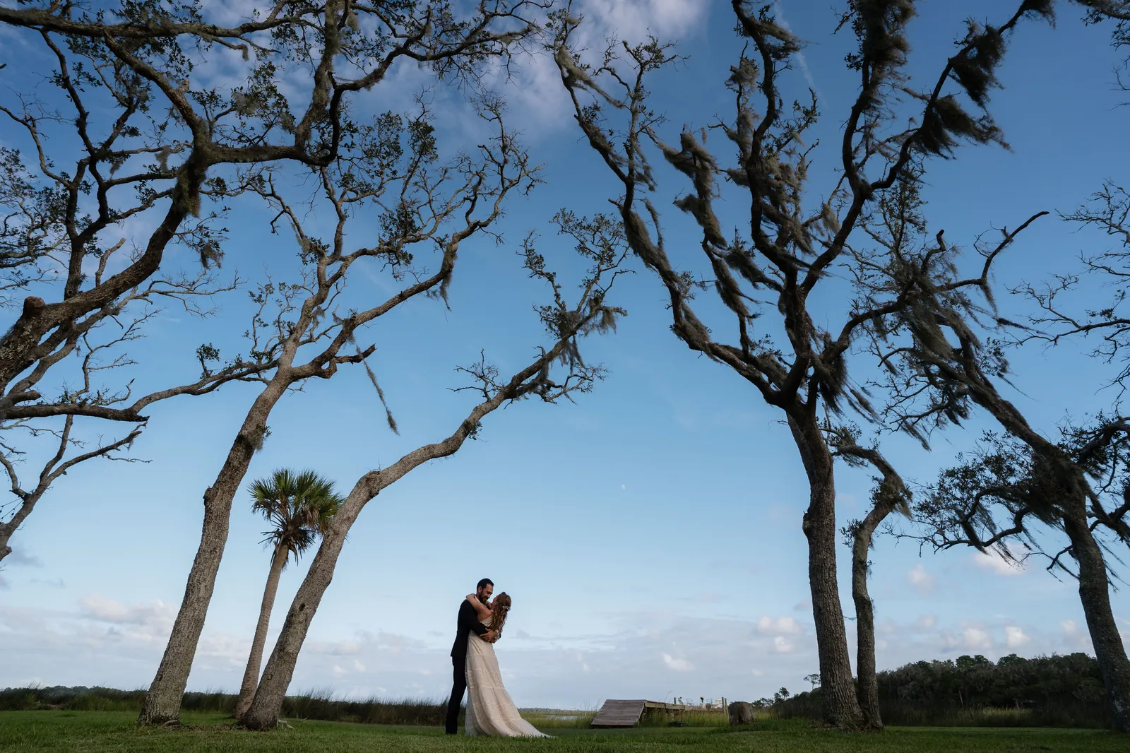 Couple embracing under Spanish moss-draped oak trees