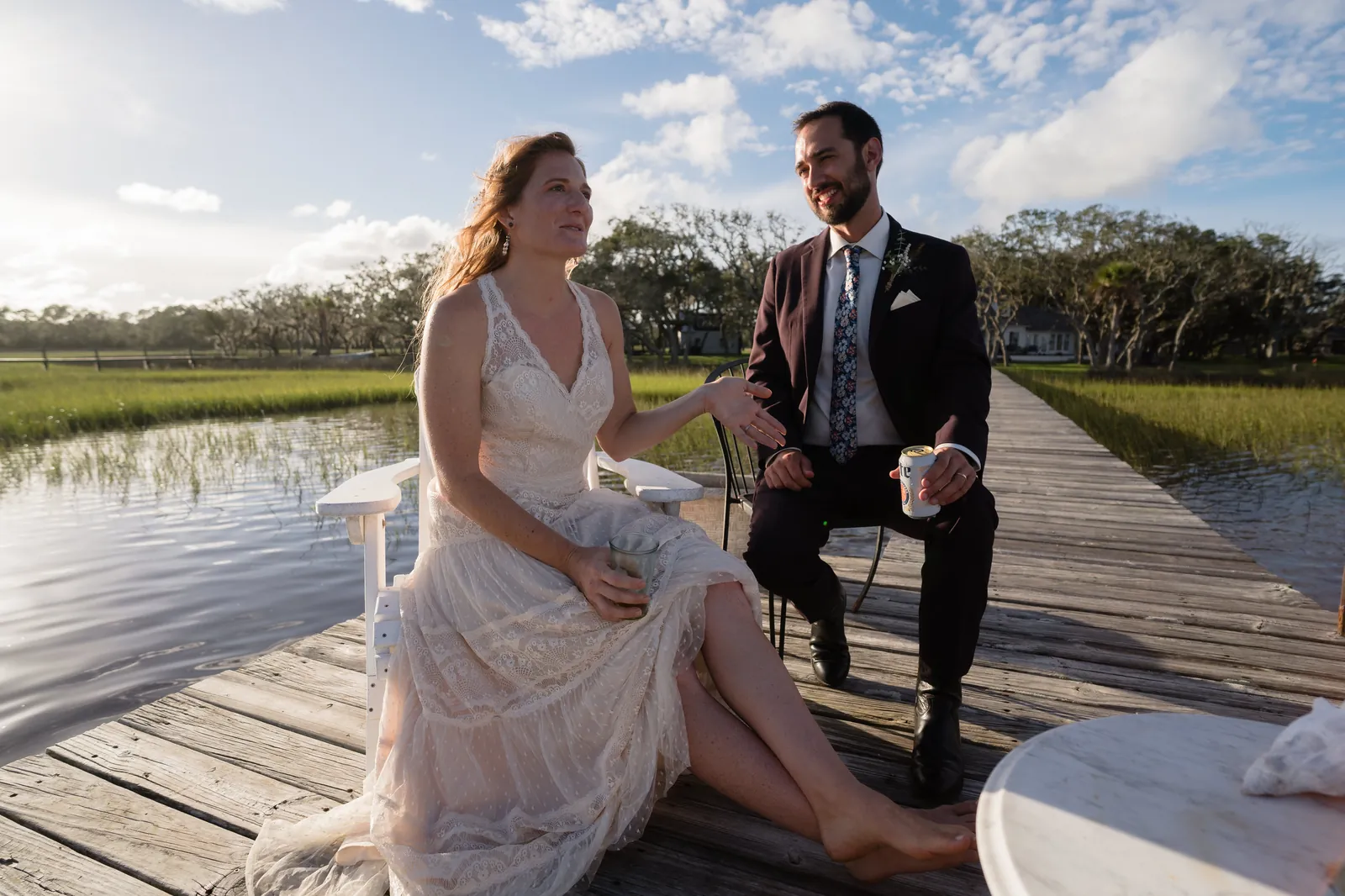 Couple relaxing on the dock with drinks overlooking the marsh