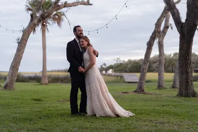 Couple embracing under string lights at dusk
