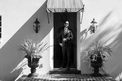 Groom portrait in doorway of Mediterranean-style home in black and white