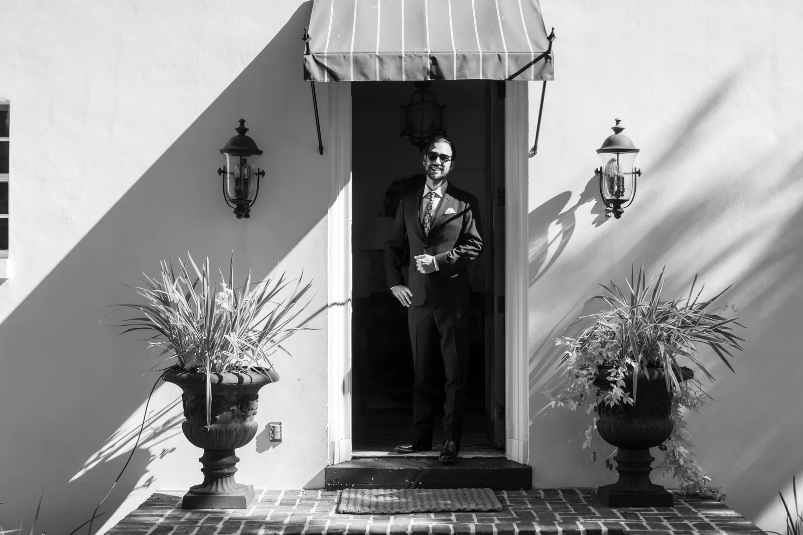 Groom portrait in doorway of Mediterranean-style home in black and white