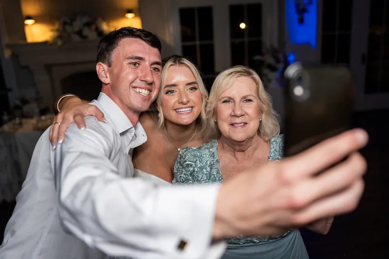 Two men and two women pose together for a selfie on the dance floor, smiling at the camera.