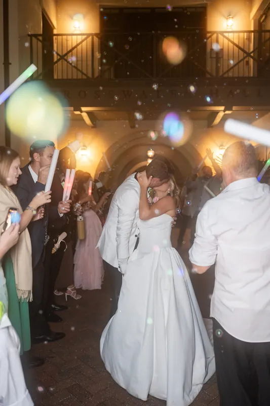 Guests walk through a glowing tunnel of sparklers and handheld lights during the nighttime celebration.